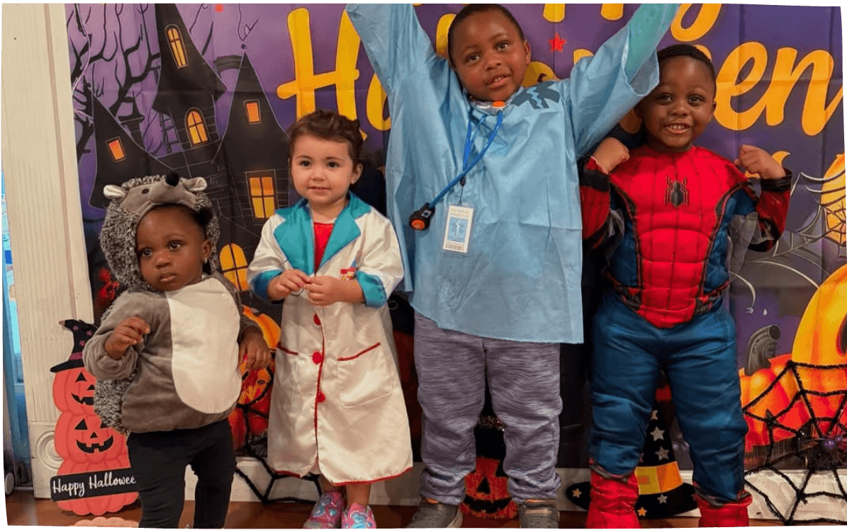 Halloween costumes and smiles in group photo at Mama Bear Daycare, daycare in Lake Forest.